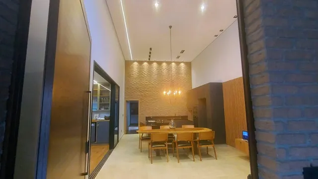 Sala de jantar de casa de alto padrão, com lustre e iluminação em LED